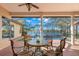 Enclosed patio featuring a scenic view of the pool and lake, with comfortable seating and shade at 1160 Darlington Oak Ne Dr, St Petersburg, FL 33703