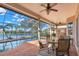 A covered patio with a table and chairs overlooks the pool and lake at 1160 Darlington Oak Ne Dr, St Petersburg, FL 33703