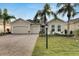 Beautiful tan two-story house with a three-car garage and lush landscaping at 1533 Emerald Dunes Dr, Sun City Center, FL 33573