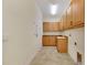 Bright laundry room with light wood cabinets and tile floor at 1533 Emerald Dunes Dr, Sun City Center, FL 33573