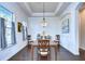 Elegant dining room with hardwood floors, chandelier, and large windows at 11521 Lake Lucaya Dr, Riverview, FL 33579