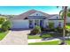 Beautiful two-story house with gray roof, light blue exterior, and a paver driveway at 11521 Lake Lucaya Dr, Riverview, FL 33579