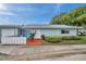 Charming single-story home featuring a tidy front yard, patio with colorful seating, and an attached garage at 1606 Berwick Ct # 10B, Palm Harbor, FL 34684