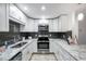 Well-equipped kitchen with stainless appliances, granite countertops, and sleek white cabinetry at 1606 Berwick Ct # 10B, Palm Harbor, FL 34684
