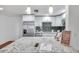 Modern kitchen with white cabinets, granite countertops, and stainless steel appliances at 1606 Berwick Ct # 10B, Palm Harbor, FL 34684
