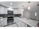 Modern kitchen with white cabinets, stainless appliances and a large granite countertop island at 1606 Berwick Ct # 10B, Palm Harbor, FL 34684