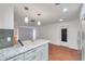 Bright kitchen with granite countertops, subway tile backsplash, and modern pendant lighting at 1606 Berwick Ct # 10B, Palm Harbor, FL 34684