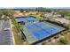 An aerial shot features community tennis courts with well-maintained surfaces and professional fencing at 1606 Berwick Ct # 10B, Palm Harbor, FL 34684