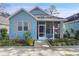 Charming light blue house with a screened porch and well-manicured landscaping at 6212 Abbott Station Dr, Zephyrhills, FL 33543