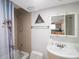 Clean bathroom with shower/tub combo, pedestal sink, and tiled walls at 600 71St Ave # 17, St Pete Beach, FL 33706