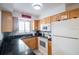 Efficient galley kitchen with light wood cabinets, granite countertops, and stainless steel appliances at 600 71St Ave # 17, St Pete Beach, FL 33706