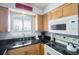 Bright kitchen featuring light wood cabinets, granite countertops, and built-in microwave at 600 71St Ave # 17, St Pete Beach, FL 33706