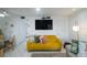 Comfortable living room showcasing a mustard yellow sofa, large TV, and stylish decor at 600 71St Ave # 17, St Pete Beach, FL 33706