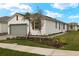 White house with gray garage door, brown shutters, and a paved driveway at 12310 Hearts Ease St, Venice, FL 34293