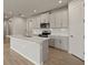 Modern kitchen with gray cabinets, quartz countertops, and an island at 12310 Hearts Ease St, Venice, FL 34293