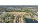 Aerial view of community featuring a pool, tennis court, and lush landscaping at 1435 Millstream Ln # 202, Dunedin, FL 34698