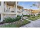 Exterior view of condo building with landscaped grounds at 1435 Millstream Ln # 202, Dunedin, FL 34698