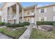 Two-story building with a walkway and manicured landscaping at 1435 Millstream Ln # 202, Dunedin, FL 34698