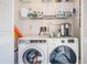 Bright laundry room with washer, dryer, and shelving at 1435 Millstream Ln # 202, Dunedin, FL 34698