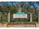 Community entrance sign with brick pillars and flowers at 1510 Mahogany Ln # 606, Palm Harbor, FL 34683