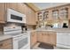 Well-equipped kitchen featuring white appliances and wood cabinets at 1510 Mahogany Ln # 606, Palm Harbor, FL 34683