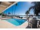 Outdoor pool, seating, and dock with boat lift offer waterfront living and stunning views at 807 Bay Point Dr, Madeira Beach, FL 33708
