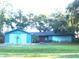 Ranch home with blue siding, attached garage, and a well-manicured lawn at 8201 Sunny Vale Pl, Tampa, FL 33615