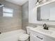 Modern bathroom with gray tile, white vanity, and black fixtures at 1548 Illinois Ave, Palm Harbor, FL 34683