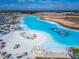 Aerial view of a crystal-clear lagoon with beach and water features at 31451 Moniker Mast Ln, San Antonio, FL 33576