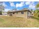 View of the side of the home showing the luscious lawn with water views and the home's exterior at 945 Bayshore Dr, Tarpon Springs, FL 34689