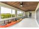 Spacious sunroom with water views, wood ceiling, ceiling fans, and large windows bringing the outdoors in at 945 Bayshore Dr, Tarpon Springs, FL 34689