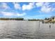 Expansive waterfront view of calm waters with a few docks visible on a bright and sunny day with puffy clouds at 945 Bayshore Dr, Tarpon Springs, FL 34689