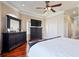 Main bedroom with large TV, dresser, and hardwood floors at 140 Brightwater Dr # 6, Clearwater Beach, FL 33767