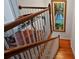 Elegant wooden staircase with a tropical art piece and glass top accent table at 140 Brightwater Dr # 6, Clearwater Beach, FL 33767