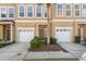 Front view of two-story townhouses with attached garages and landscaping at 3010 Bayshore Pointe Dr, Tampa, FL 33611