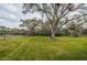 Spacious backyard with lush grass and mature trees at 7510 Riverview Dr, Riverview, FL 33578