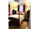 Cozy bedroom with a wooden four-poster bed, hardwood floors, and red curtains at 3246 Prescott N St, St Petersburg, FL 33713