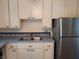 White cabinets, double sink, and stainless steel fridge at 3246 Prescott N St, St Petersburg, FL 33713