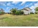Large backyard with lush green grass, mature trees, and plenty of space for recreation at 4825 Benito Ct, Bradenton, FL 34211