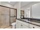 Modern bathroom featuring a granite countertop, walk-in shower with glass doors, and neutral color scheme at 4825 Benito Ct, Bradenton, FL 34211
