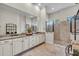 Well-lit primary bathroom with double sink vanity, neutral cabinets, and a walk-in shower at 4825 Benito Ct, Bradenton, FL 34211