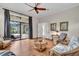Cozy living room with rattan furniture, hardwood floors, and a large glass door overlooking the pool area at 4825 Benito Ct, Bradenton, FL 34211