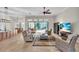 Open concept living room with tile floors, a ceiling fan, and sliding glass doors to the pool at 4825 Benito Ct, Bradenton, FL 34211