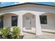 Front view of charming house with white exterior and arched entryway at 6318 S Renellie Ct, Tampa, FL 33616