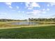 Serene view of a lake with a fountain, lush landscaping, and homes at 20644 Swallow Tail Ct, Venice, FL 34293