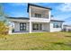 Modern home with covered patio, grassy yard, and second story balcony at 32354 Wetland Bird Vw, San Antonio, FL 33576