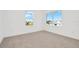 Bright bedroom with neutral carpeting and two large windows at 32354 Wetland Bird Vw, San Antonio, FL 33576