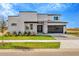 Two-story modern home with gray and white exterior, stone accents, and a black garage door at 32354 Wetland Bird Vw, San Antonio, FL 33576