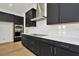 Modern kitchen with dark cabinetry, white quartz countertops, and stainless steel appliances at 32354 Wetland Bird Vw, San Antonio, FL 33576