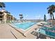 Community pool with lounge chairs and tables at 7540 Sunshine Skyway S Ln # 220, St Petersburg, FL 33711